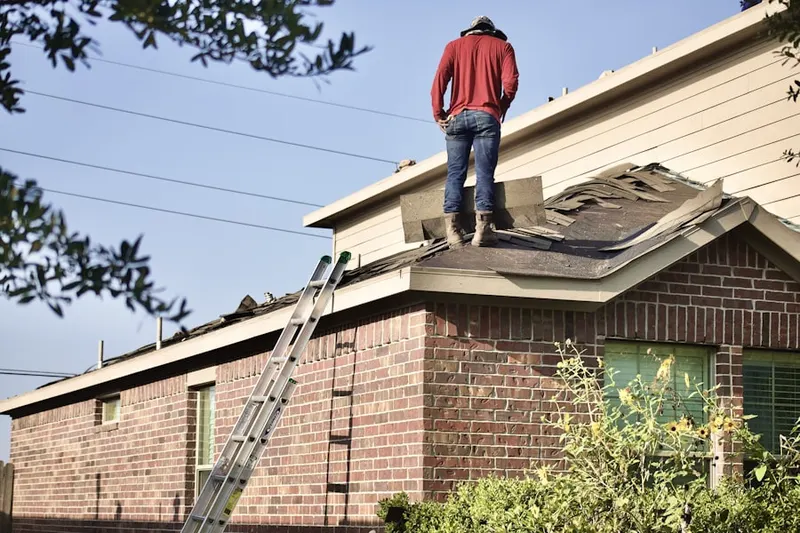Professional roofer working on a residential roof in West Bedford